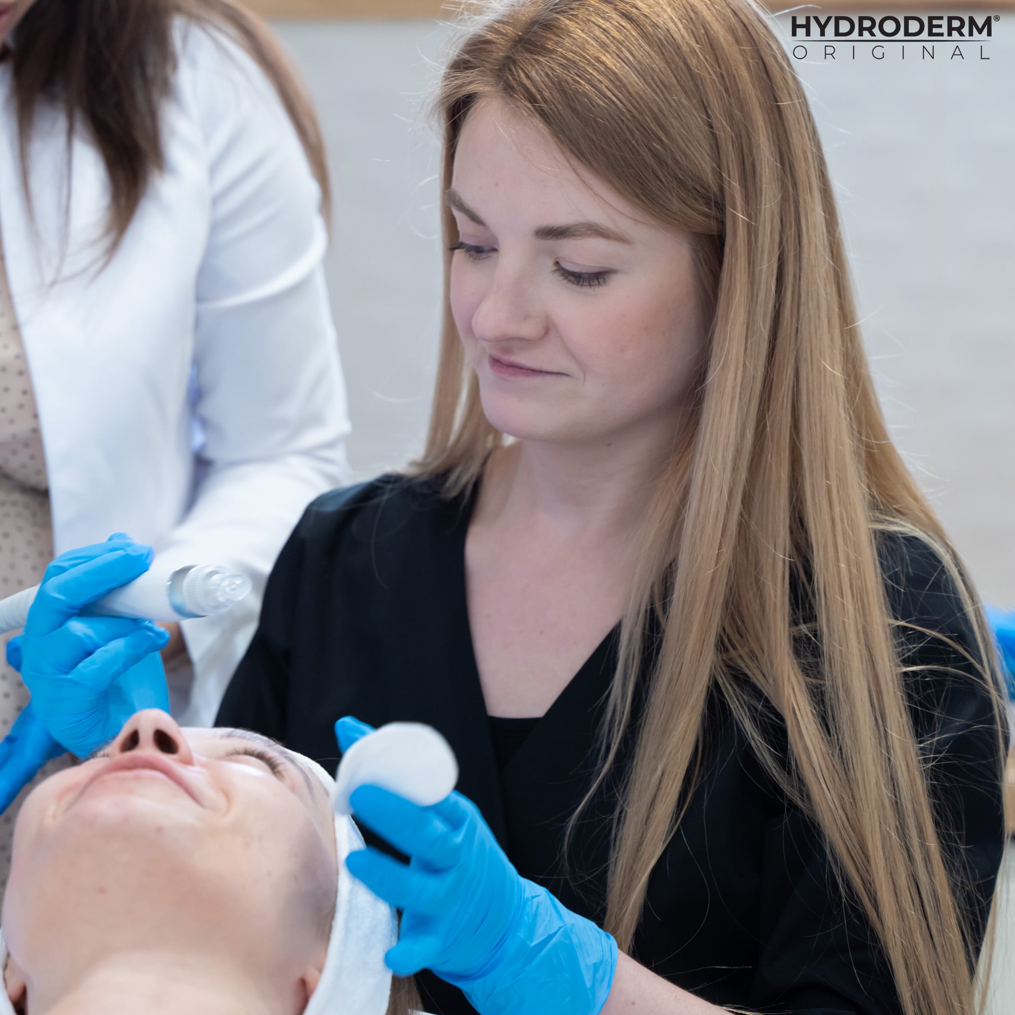 Podczas szkolenia klientka z Pruchnika ćwiczy obsługiwać maszynę Hydroderm pod okiem kosmetologa