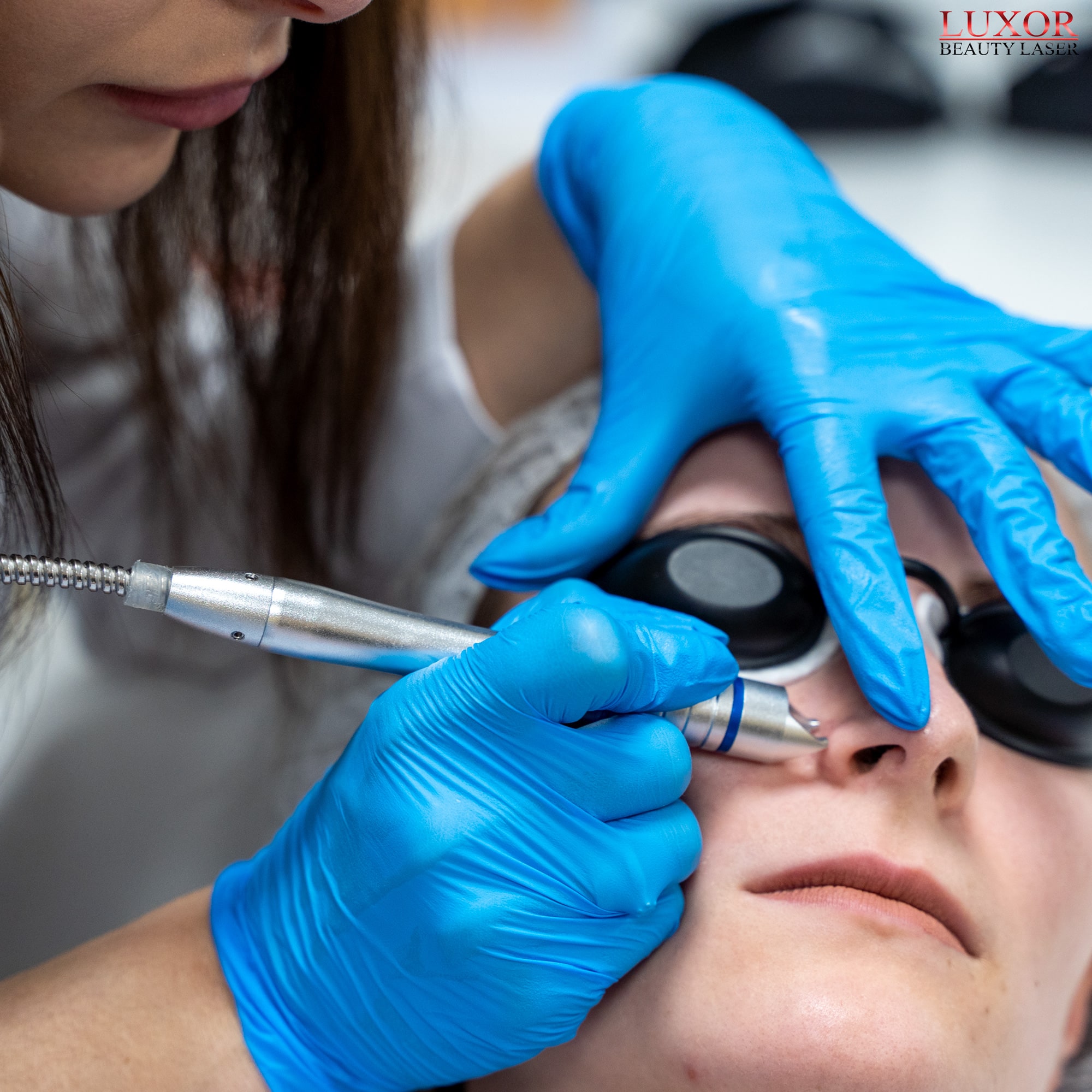 Kosmetolog instruuje uczestniczki jak przesuwać głowicę laserową w okolicy nosa